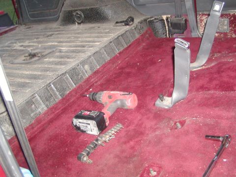 1991 Ford Bronco - Tools are laid out on the bare floor of a vehicle, suggesting interior work is in progress.