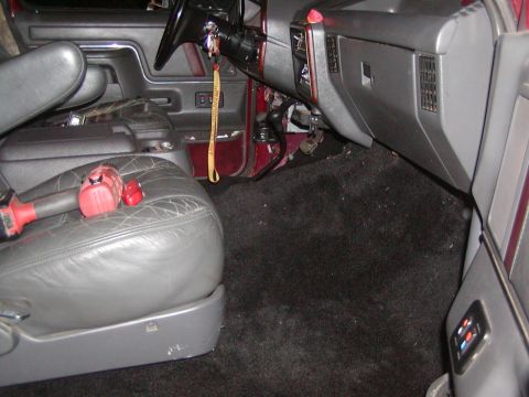 1991 Ford Bronco - The interior of a vehicle, a driver's seat with a drill and battery on it, and the dashboard area.