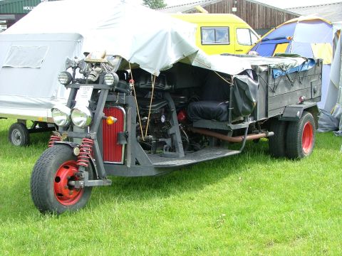 2001 Ford Fiesta - This custom-built trike features a unique front end and a trailer, with tents set up in the background.