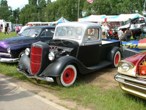 2001 Ford Fiesta - A classic black and silver pickup truck with a prominent red grille and red wheels is displayed at an outdoor event.