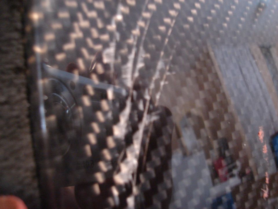 Interior carbon fiber trim with reflection of dashboard and steering wheel