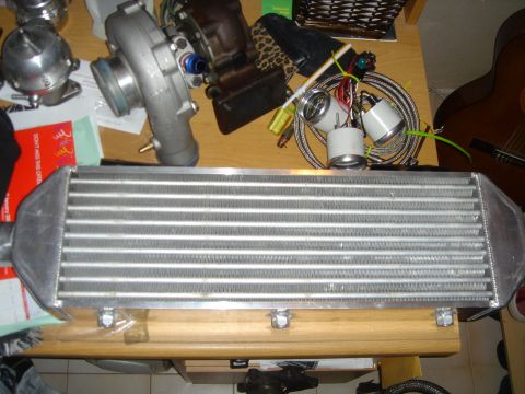 1995 Mazda MX-6 - Aftermarket intercooler and turbo parts laid out on a table.