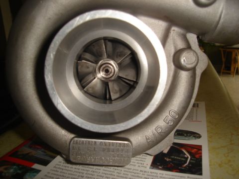 1995 Mazda MX-6 - Close-up of a turbocharger part, with visible markings and a serial number plate.