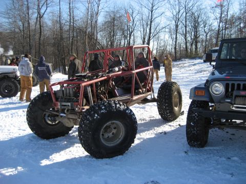 1991 Ford Bronco - Two off-road vehicles, a custom buggy and a Jeep, sit in the snow on a sunny day.