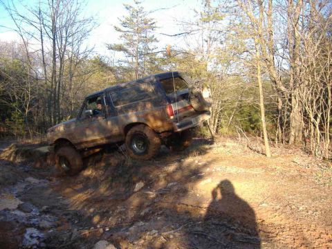 1991 Ford Bronco - 1991 Ford Bronco navigating a challenging off-road trail.