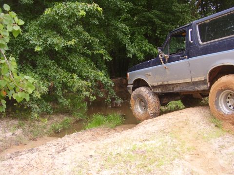 1991 Ford Bronco - This 1991 Ford Bronco navigates a challenging off-road course, splashing through mud and water.