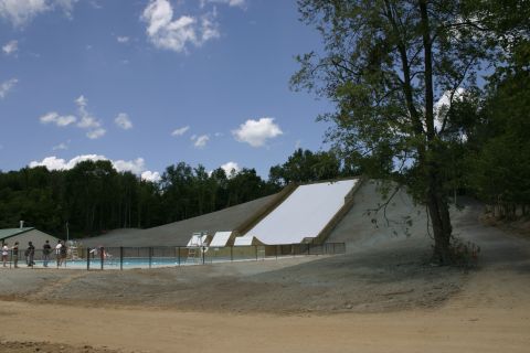1997 Ford Probe - A ski jump ramp and swimming pool are visible at an outdoor recreation area on a sunny day.