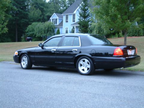 2002 Ford Crown Victoria - This black 2002 Ford Crown Victoria LX Sport sedan is seen from the side parked on a residential street.