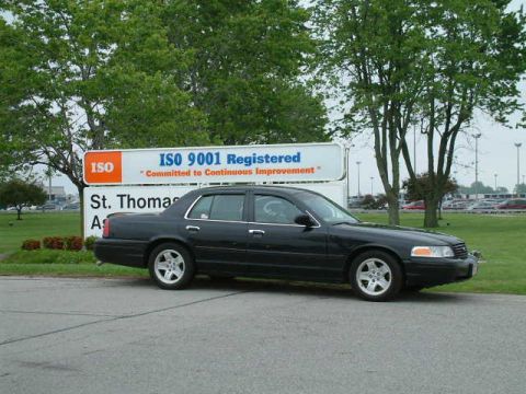 2002 Ford Crown Victoria - Black 2002 Ford Crown Victoria parked near a sign.