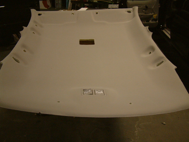 Off-white car headliner panel removed and laid on garage floor