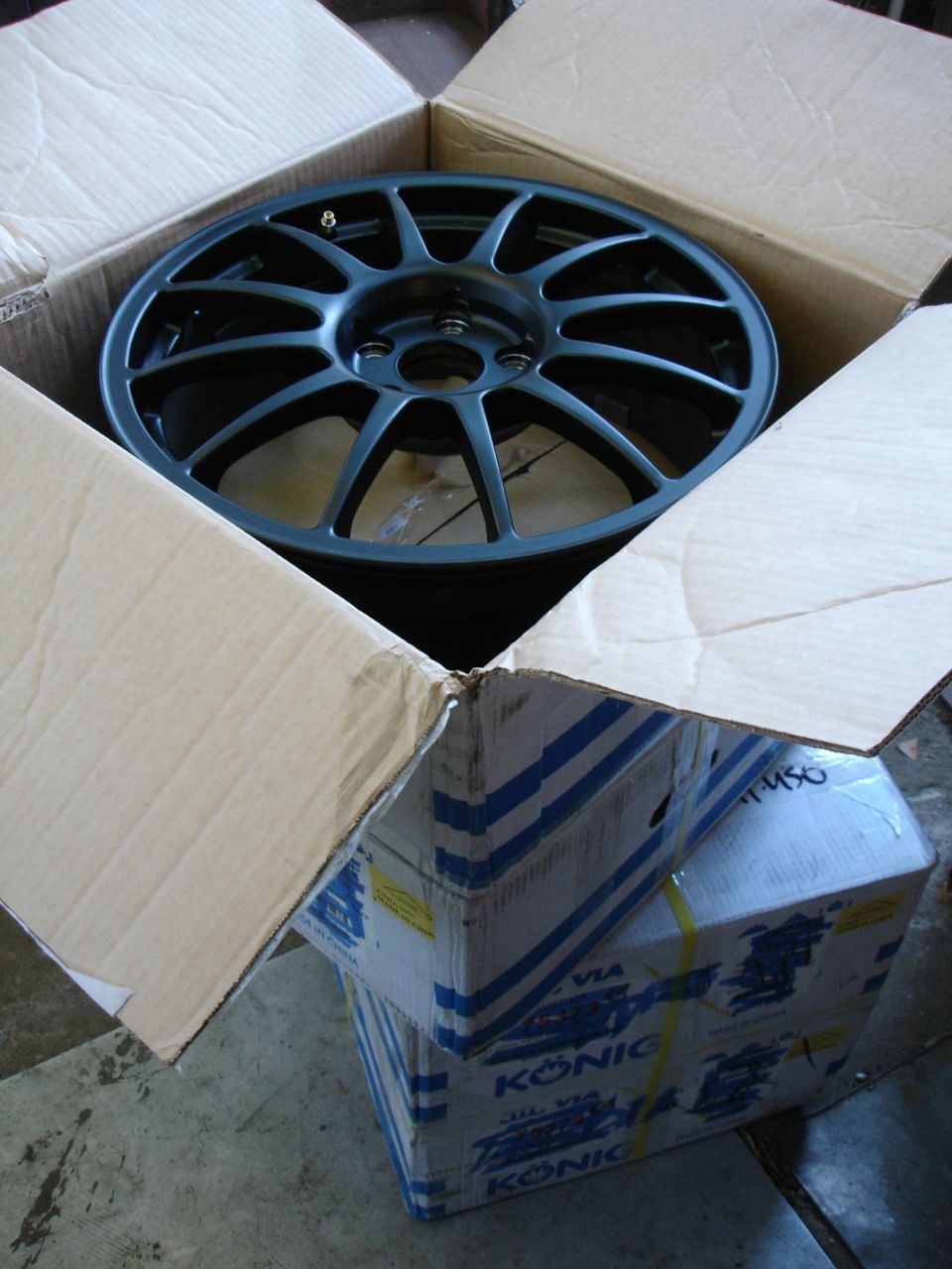 Two boxes with Konig branding, one open showing a black multi-spoke wheel