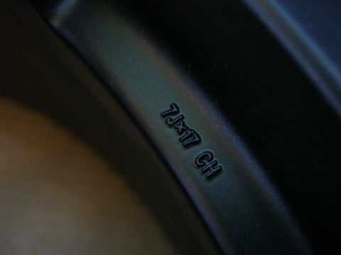 1993 Ford Taurus - A close-up view of a black wheel rim shows stamped markings indicating its size and specifications.
