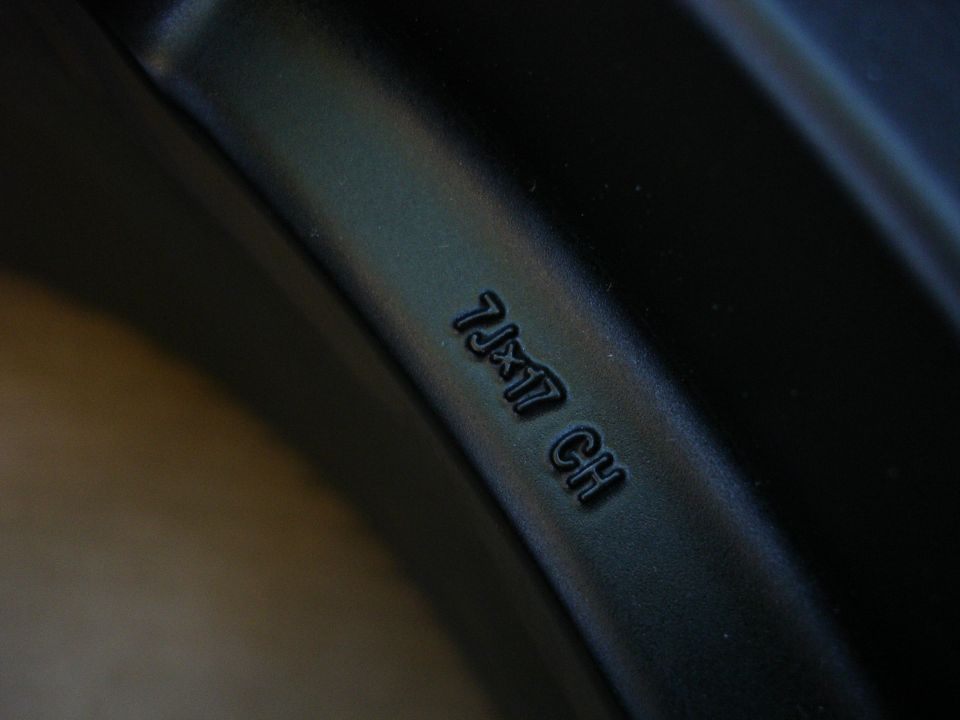 Close-up of a black wheel rim with "7Jx17 CH" stamped into it