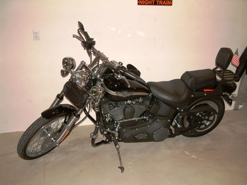 Black 2003 Harley-Davidson Softail FXSTB Night Train motorcycle parked indoors, 3q front view, chrome accents, black seat