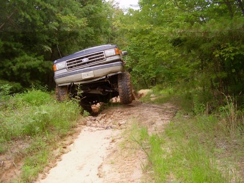 1991 Ford Bronco - Ford F-Series truck with lifted suspension navigating a dirt trail.