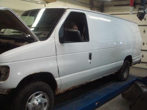 1996 Ford Bronco - A white cargo van is shown from the side, with visible rust along the bottom edges of the body.