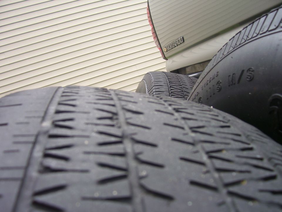 Tires stacked in front of a truck bed with 'Silverado' badge