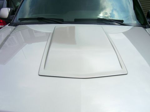 2004 Chevrolet Silverado 1500 - The hood of a silver truck features a raised center section, with the windshield and wipers visible at the top.