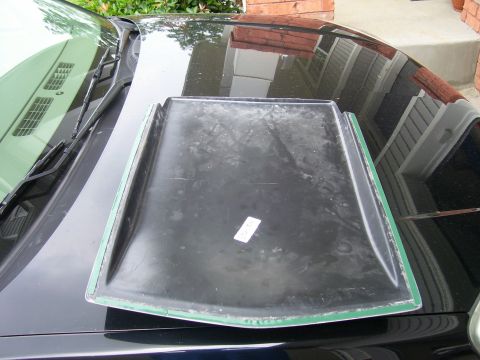 2004 Chevrolet Silverado 1500 - A black hood scoop with green trim is placed on the hood of a black vehicle.
