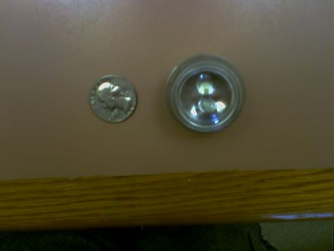 2001 Ford Crown Victoria - A dime is shown next to a small, clear light fixture, possibly for size comparison.