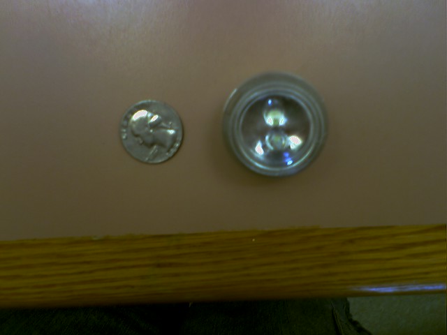 Dime next to a small round light fixture