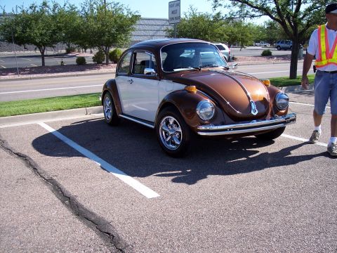1972 Ford Ranchero - A two-tone Volkswagen Beetle is parked in a lot on a sunny day.