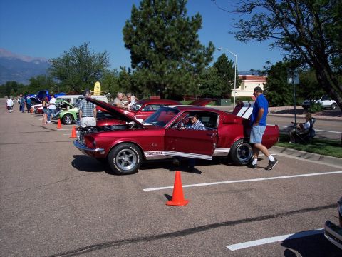1972 Ford Ranchero - A red 1968 Ford Mustang Shelby GT500 is displayed with its hood and door open at an outdoor car show.