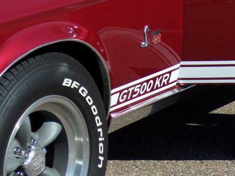 1972 Ford Ranchero - The side of a red car shows a GT500 KR stripe and a Shelby Cobra emblem with '428' on the fender.