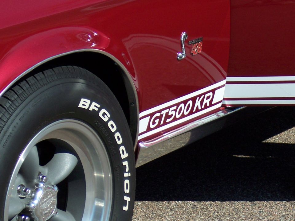 Close-up of a red 1968 Ford Mustang GT500 KR side stripe and fender badge
