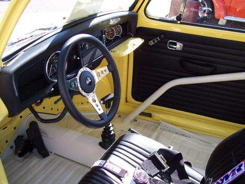1972 Ford Ranchero - The interior of a yellow Volkswagen Beetle features a custom steering wheel, racing seats, and a roll cage.