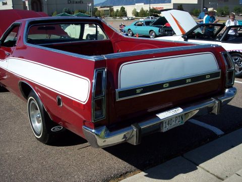1972 Ford Ranchero - Rear view of a red 1972 Ford Ranchero at a car show, showing its distinctive tailgate and white side stripe.