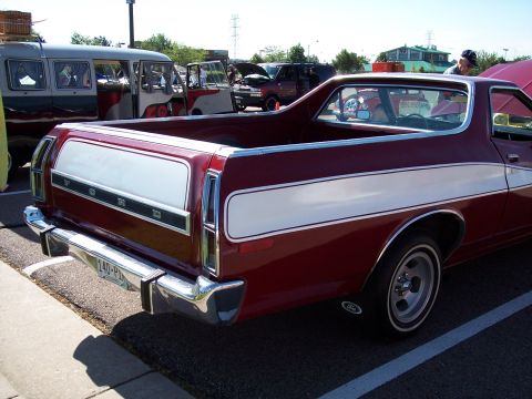 1972 Ford Ranchero - A red 1972 Ford Ranchero is parked next to other vehicles, including a van.