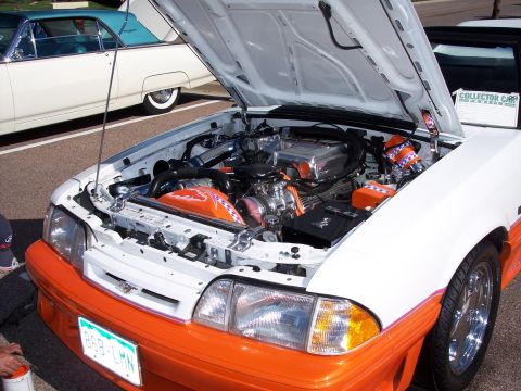 1972 Ford Ranchero - Customized engine bay of a white and orange vehicle, with a prominent chrome intake and orange accents.