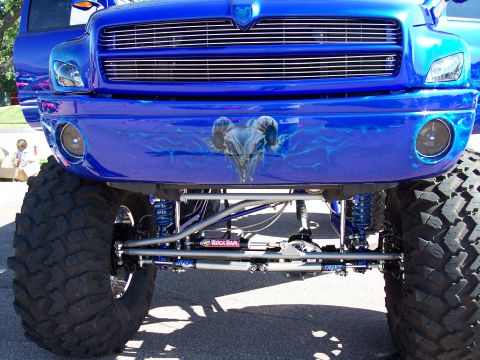 1972 Ford Ranchero - A heavily modified blue truck with large tires and a custom ram skull graphic on the front bumper is shown.