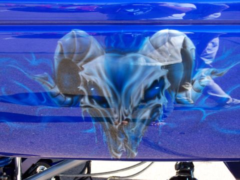 1972 Ford Ranchero - A custom airbrushed skull design with blue flames adorns the side of a blue vehicle.
