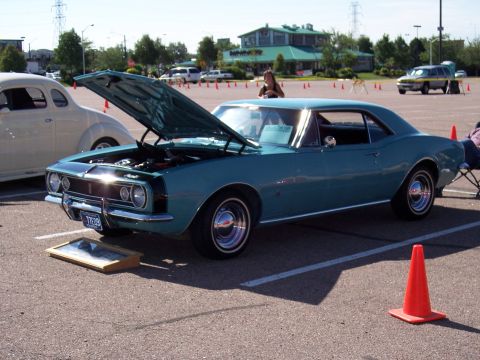 1972 Ford Ranchero - A teal 1967 Chevrolet Camaro is displayed with its hood open at an outdoor car show.