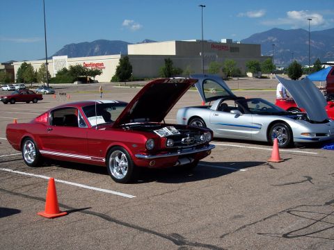 1972 Ford Ranchero - Two classic American sports cars, a Ford Mustang and a Chevrolet Corvette, displayed at an outdoor car show.