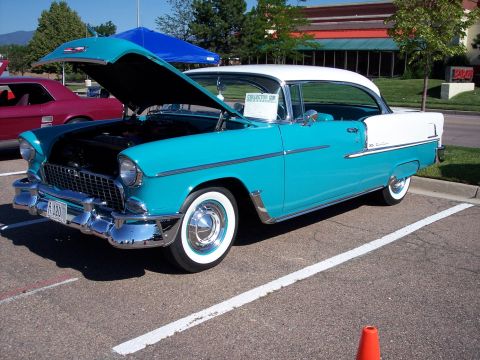 1972 Ford Ranchero - A two-tone 1955 Chevrolet Bel Air coupe is displayed with its hood open at an outdoor event.