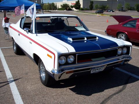 1972 Ford Ranchero - White and blue 1970 AMC AMX with red stripe and hood scoops parked in a lot.