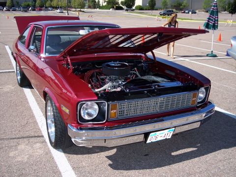 1972 Ford Ranchero - A red coupe is parked in a lot with its hood open, revealing the engine compartment.