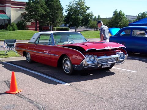 1972 Ford Ranchero - A red 1961 Ford Thunderbird is displayed with its hood open, parked next to another vehicle at an outdoor event.