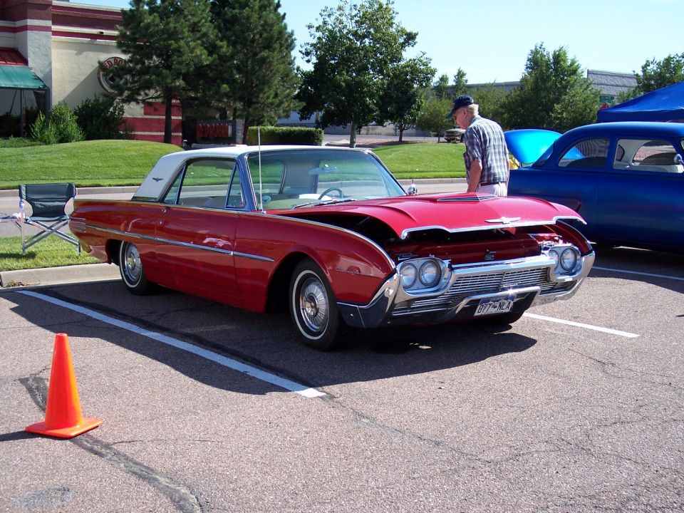 Red 1961 Ford Thunderbird with hood open, front view. License plate reads BTT-902