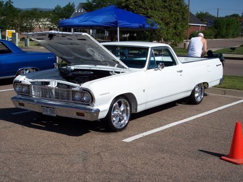 1972 Ford Ranchero - White 1964 Chevrolet El Camino on display, hood raised to show the engine bay.