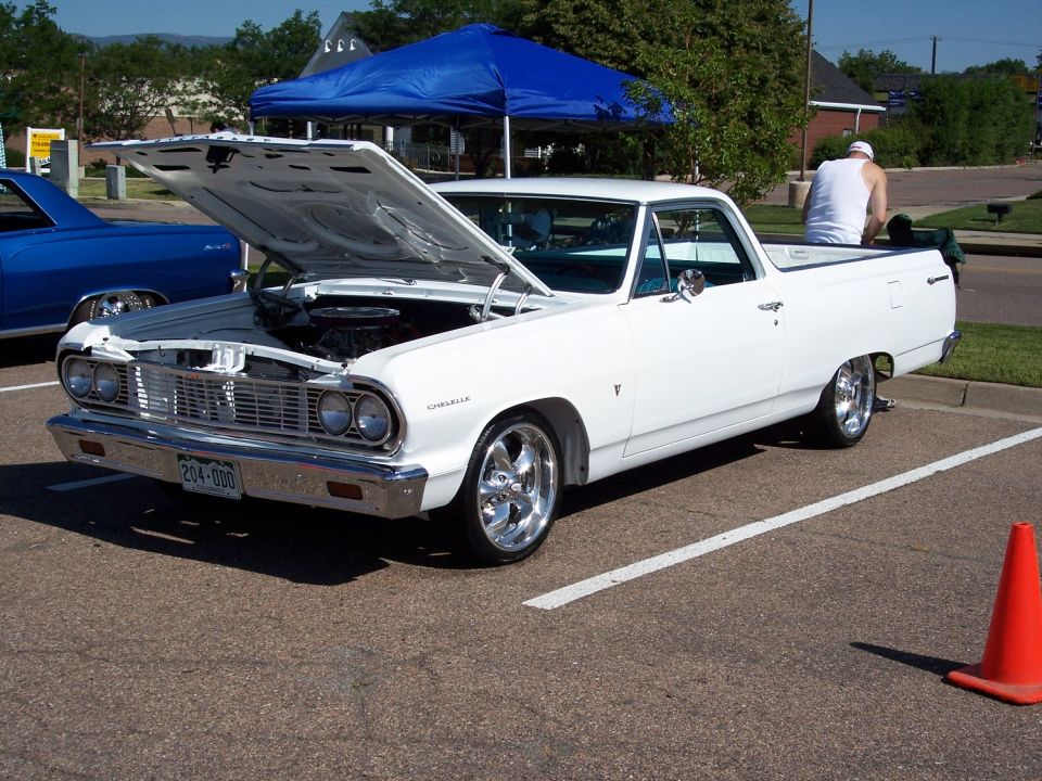 White 1964 Chevrolet El Camino with hood open, parked next to a blue vehicle