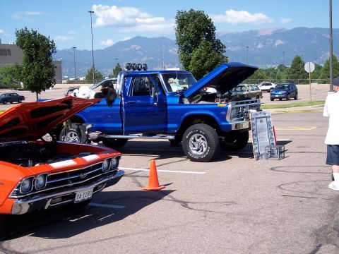 1972 Ford Ranchero - A blue pickup truck is displayed with its hood open at an outdoor event, with other vehicles present.