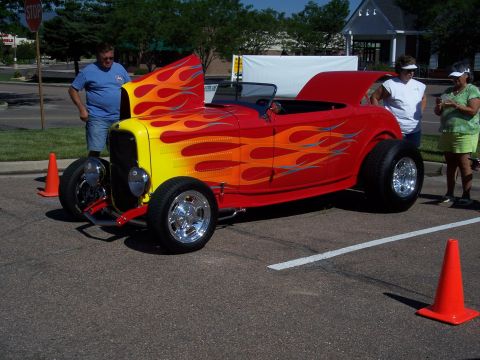 1972 Ford Ranchero - A custom hot rod with flame paintwork is displayed with its hood open.