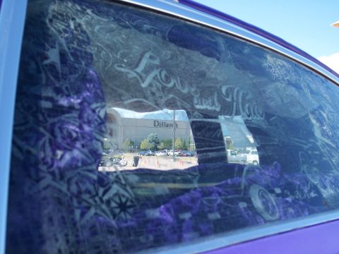 1972 Ford Ranchero - The interior of a customized car is shown, with graffiti art on the window reflecting a shopping mall.