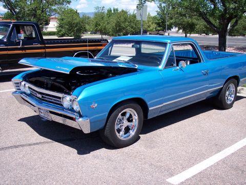 1972 Ford Ranchero - A blue 1967 Ford Ranchero is parked at an outdoor event, with its hood raised to reveal the engine.