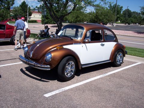 1972 Ford Ranchero - A two-tone Volkswagen Beetle is parked at a car show, with another vehicle to its left.