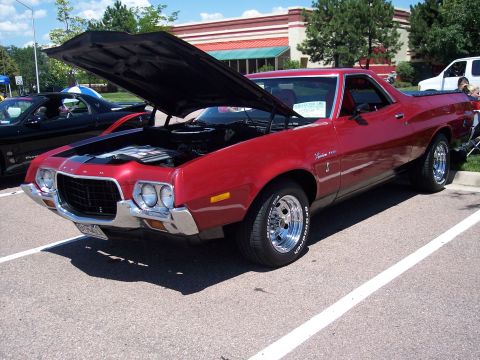 1972 Ford Ranchero - A red 1972 Ford Ranchero is displayed with its hood open at a car show, parked next to another vehicle.